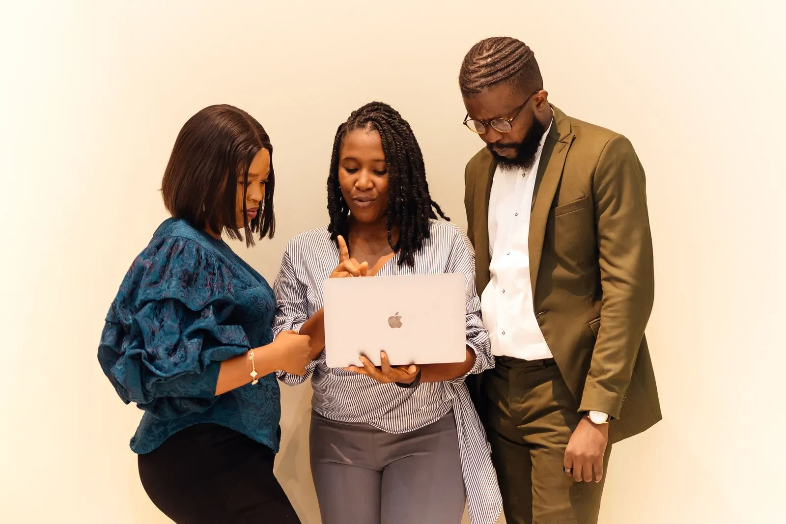 Three colleagues in Lagos look over a laptop together
